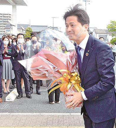 職員に出迎えられて初登庁する上定昭仁市長＝松江市末次町、市役所前