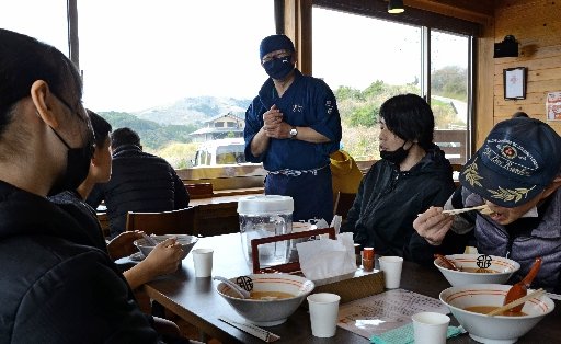 にぎわう店内で客と語らう野本栄二さん(右から3人目)=島根県知夫村、レストハウス神島