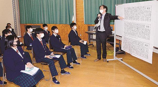 松村健次論説委員長（右）からコラム「明窓」について一般記事との違いを教わる生徒＝江津市二宮町神主、青陵中学校