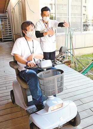 シニアカーに乗ってリハビリを行う安達和幸さん（手前）と岩崎大輔さん＝米子市上後藤３丁目、養和病院