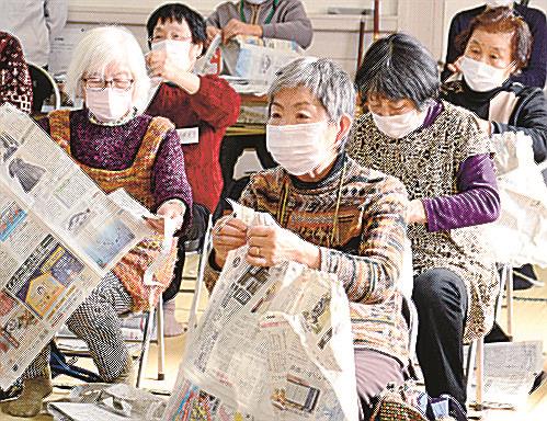 指先を使って新聞を細長く切る参加者＝出雲市大社町杵築南、大社コミニュティセンター