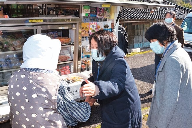 移動販売車を利用する住民に声をかける小原佐智子副看護局長（左から２人目）と近藤仁子看護局長（同３人目）＝鳥取県日野町内