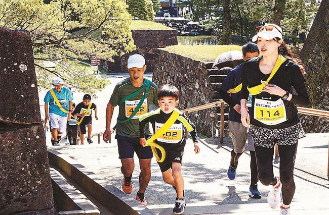 松江城の石段を駆け上がる参加者たち＝松江市殿町