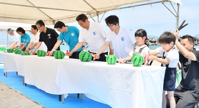 スイカ柄の紙風船を割る関係者＝米子市皆生温泉３丁目、皆生温泉海遊ビーチ