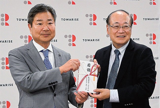 日本認知症予防学会の浦上克哉理事(右)に目録を手渡す古山英明社長=米子市東福原2丁目、ホテルわこう