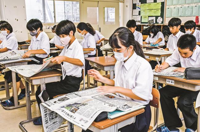 クイズの答えを探しながら新聞に目を通す生徒＝津和野町町田、津和野中学校