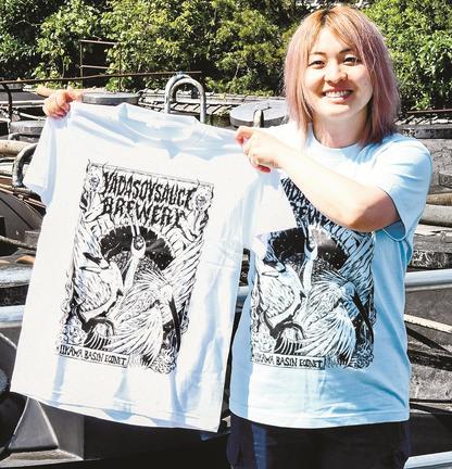 水鳥をヘビメタル風にデザインしたＴシャツを紹介する矢田敦子さん＝安来市中津町、矢田醤油店