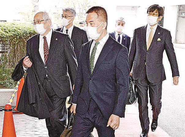 ２０２２年３月、弾劾裁判の初公判のため国会の裁判官弾劾裁判所に向かう仙台高裁の岡口基一判事（手前）と弁護団