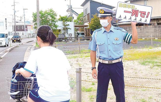 「吹き出しフリップ」で交通安全を呼びかける出雲署員＝出雲市塩冶有原町２丁目