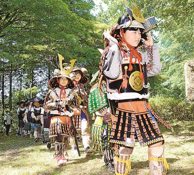 甲冑をまとい、山頂を目指す子どもたち＝島根県奥出雲町三沢、要害山