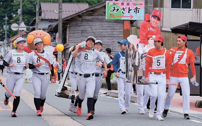 かごを担いで市街地コースを走る大会出場者たち＝島根県美郷町粕渕
