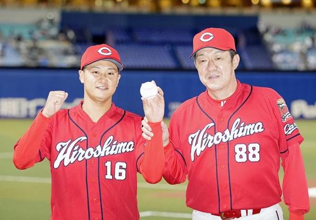 プロ初勝利を挙げた鳥取市出身の森翔平投手（左）とポーズを取る佐々岡真司監督＝９月７日、バンテリンドーム