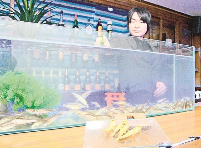 唐揚げにしたホンモロコと、カウンター上の水槽に釣り糸を垂らす日高大喜さん＝広島市中区薬研堀、Ｄ＆Ｎ