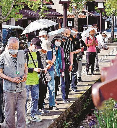 日傘を差して殿町通りを散策する観光客＝16日午後４時５分、島根県津和野町後田