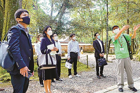 案内人（右）に出雲大社の説明を受ける会員＝出雲市大社町杵築東、出雲大社