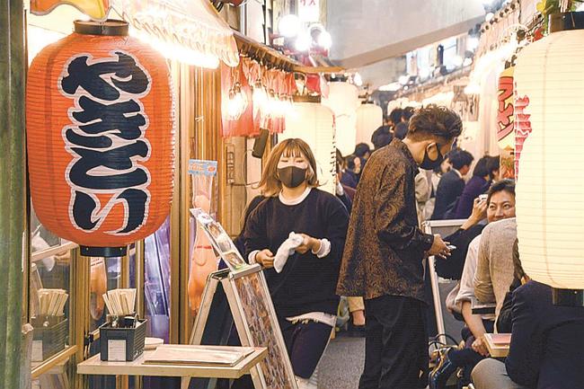 混雑する飲食店街で働く従業員（左）＝２６日、東京都千代田区