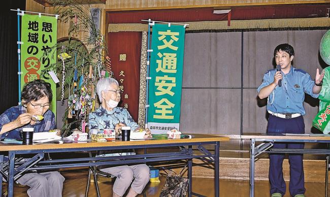 アールスメロンを食べながら益田署員（右）の話を聞く参加者＝益田市久々茂町、久々茂集会所