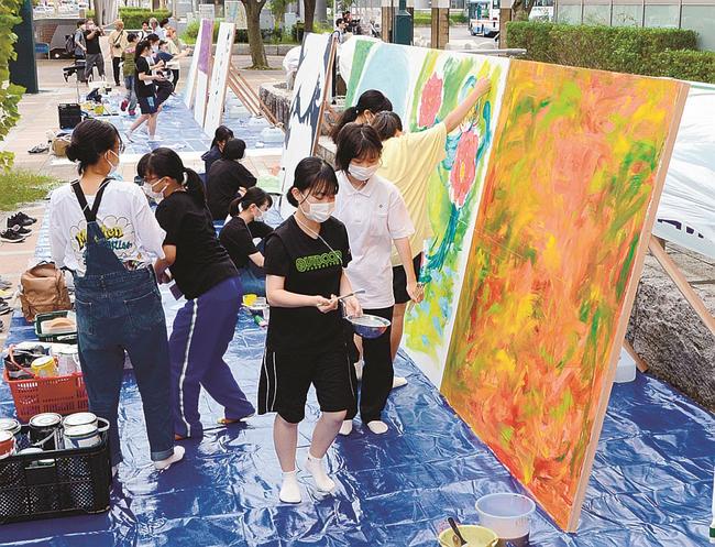 大きな木の板に向き合い、絵画や書を仕上げていく高校生＝松江市朝日町