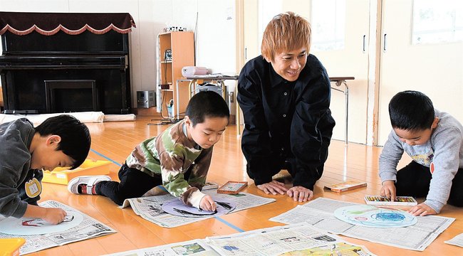 絵を描く園児を笑顔で見守るこーたさん＝出雲市西平田町、平田幼稚園