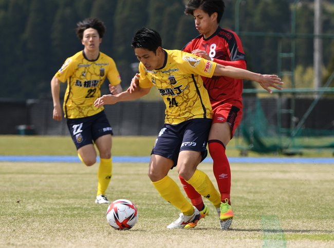 【第４節・ＦＣ神楽しまね―ホンダロックＳＣ】後半、途中出場したＦＣ神楽しまねのＭＦ加倉広海（中央）が厳しいマークの中、ボールを保持して攻め込む＝串間市総合運動公園陸上競技場（宮崎県串間市）