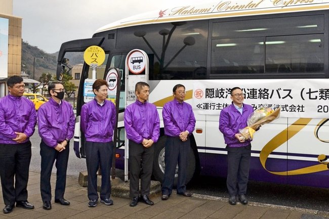 連絡バス運行を引き継ぎ、出発式で花束を受け取ったはつみ交通の赤松祐樹社長（右端）＝境港市大正町