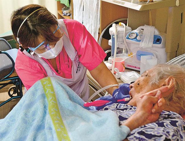 高齢者施設で入所者の口腔ケアを行う歯科衛生士＝松江市内