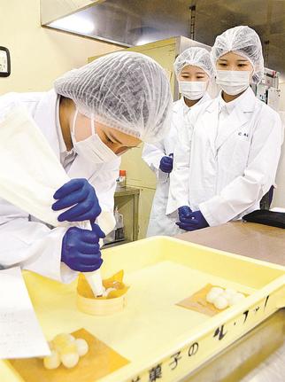 オリジナル菓子の試作品を用意する松江農林の生徒たち＝松江市八束町波入、彩雲堂本社工場