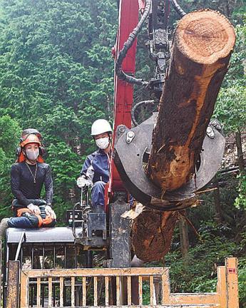 邑智郡森林組合の職員（左）から説明を受けながら林業機械を操作する生徒＝島根県邑南町上田所