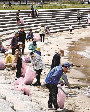 海岸を一斉清掃する山陰中央新報会の関係者たち＝松江市島根町野波、野波海浜公園