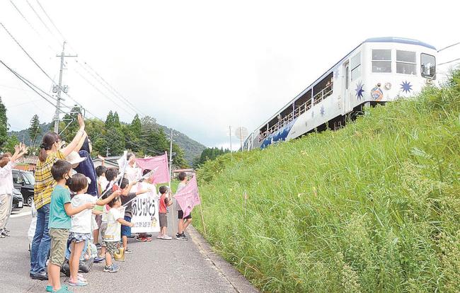 「奥出雲おろち号」に手を振る子どもたち＝島根県奥出雲町八代