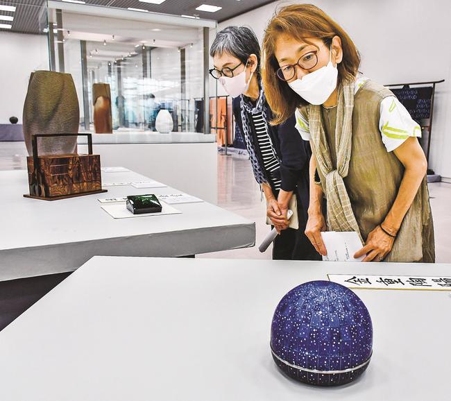 橋詰峯子さんの作品「星月夜」（手前）を見る来場者＝松江市袖師町、島根県立美術館