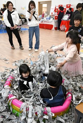 新聞紙の切れ端で作ったプールで遊ぶ子どもたち＝松江市東出雲町揖屋、ヨリアイーナ東出雲
