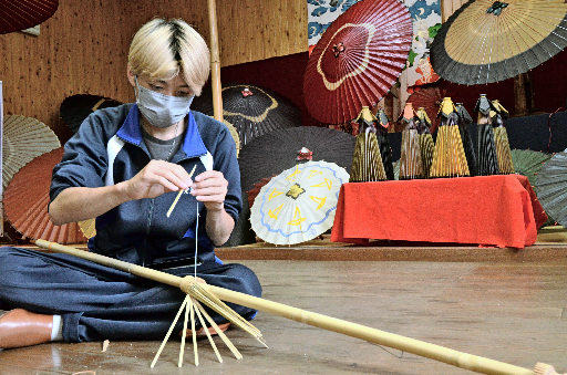 真剣な表情で傘の製作に挑戦する生徒＝米子市淀江町淀江、和傘伝承館