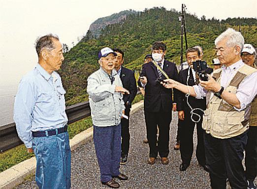池田久之助さん（左から２人目）の目撃証言を記録する特定失踪者問題調査会のメンバー＝島根県隠岐の島町那久、那久岬