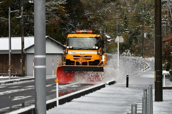 道路に残った雪をかく除雪車=益田市匹見町道川