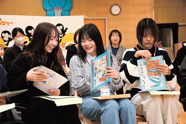 タイムカプセルから取り出した絵や親からのメッセージを読む出席者=出雲市今市町、今市幼稚園