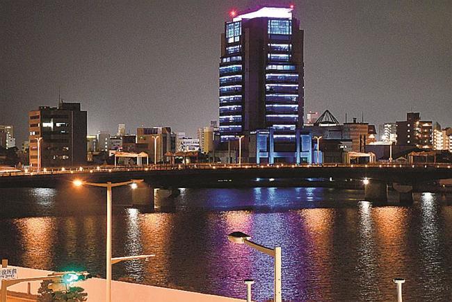 水の流れをイメージした青色にライトアップされた山陰合同銀行本店ビル＝松江市内