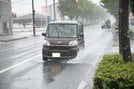 水しぶきを上げながら走行する自動車＝出雲市駅南１丁目