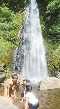 滝つぼで水遊びをする子どもたち＝鳥取市国府町雨滝、雨滝