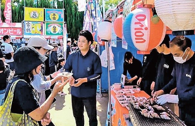 隠岐の島町の屋台で白バイ貝のつぼ焼きを買い求める来場者＝大阪府豊中市、豊島公園