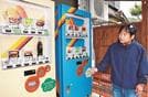 ハンバーガーの自動販売機を管理する田村武士さん＝島根県海士町福井