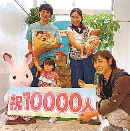 １万人目の来場者となり記念撮影する山下美子さん（左から３人目）ら（円形劇場提供）＝倉吉市鍛冶町１丁目、円形劇場くらよしフィギュアミュージアム