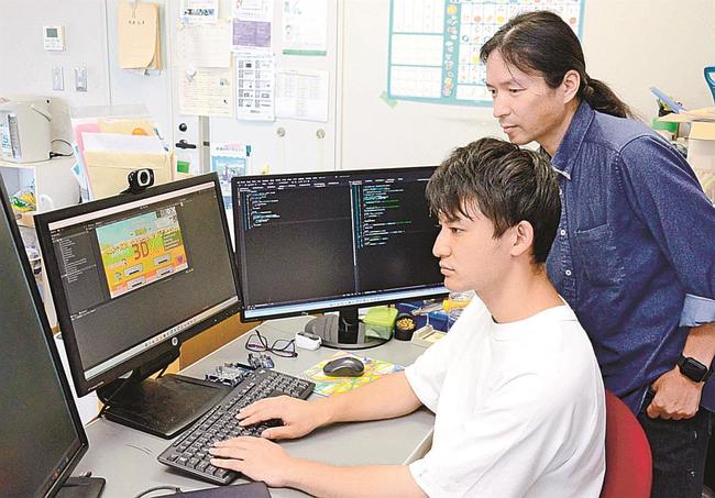 ソフトウェアの修正をする奥井大貴さん（手前）と多々納俊治さん＝松江市西川津町、島根大