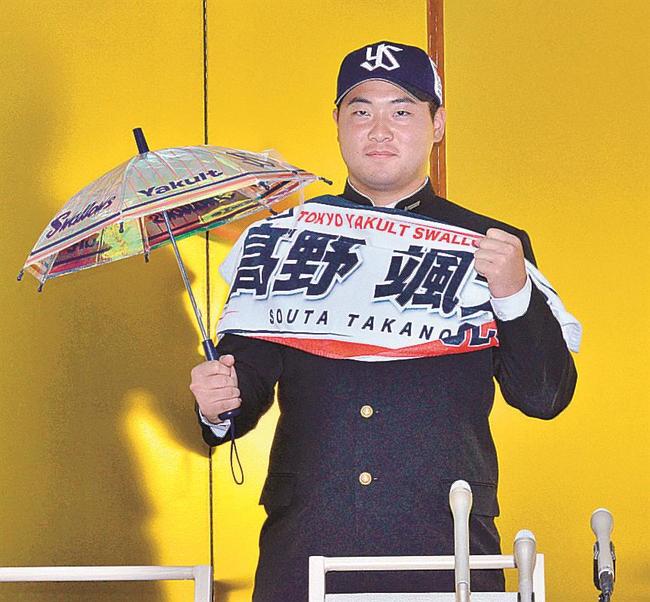 ヤクルトへの入団が決まり、球団が用意したグッズを手にする高野颯太＝ホテル一畑