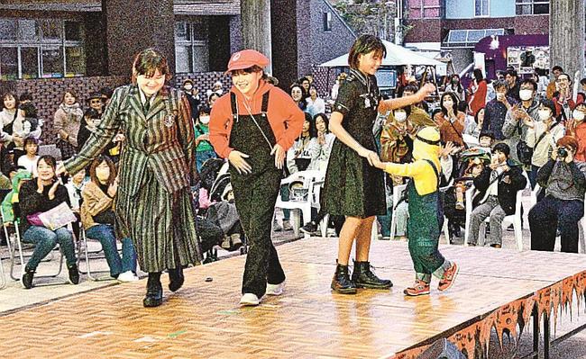 拍手を受けステージを歩く仮装コンテストの出場者＝江津市江津町、パレットごうつ