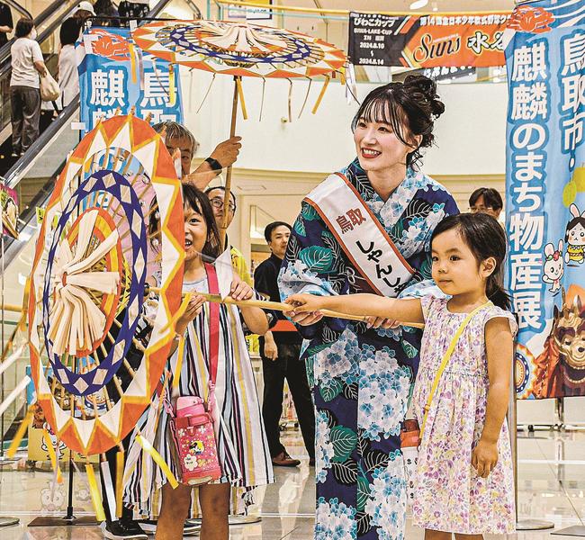 和傘を手に子どもたちと触れ合う田中あかりさん＝広島市南区、ゆめタウン広島