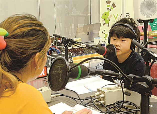 本番さながらの雰囲気でラジオ番組のゲスト体験をする子ども（右）＝松江市学園南１丁目、くにびきメッセ
