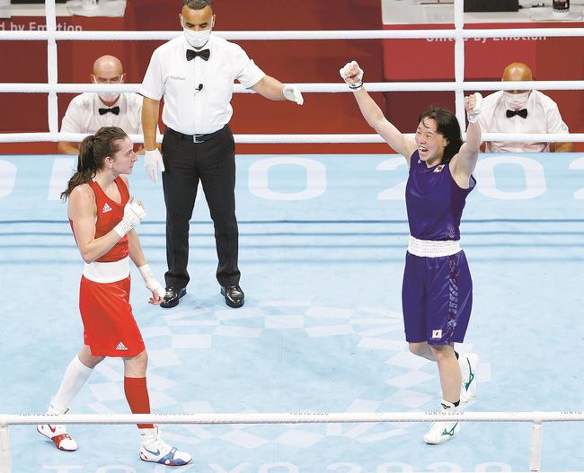 女子フェザー級準決勝で英国選手（左）を破り、ガッツポーズする入江聖奈。銀メダル以上が確定した＝両国国技館