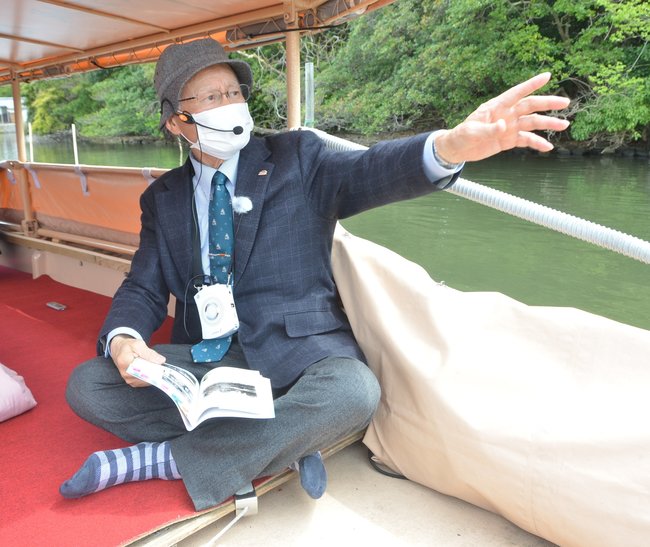 堀川遊覧船で松江城や城下町の歴史を解説する宍道正年さん＝松江市内