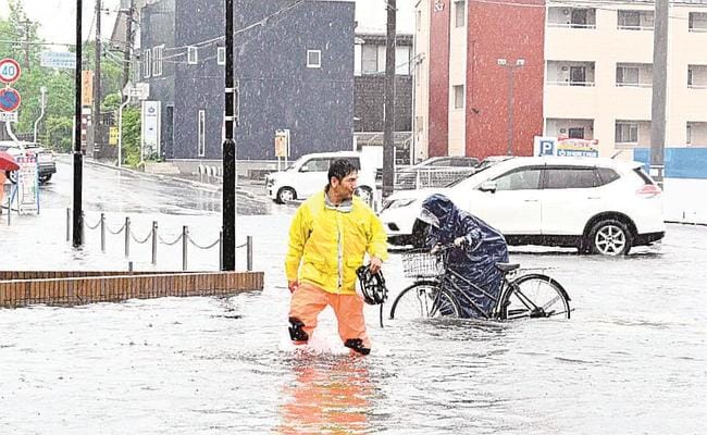 自転車を押して横断歩道を渡る通行人＝９日午後０時３１分、松江市黒田町